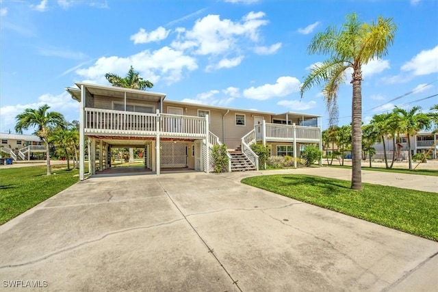 view of front of house with a front lawn, a carport, and a porch