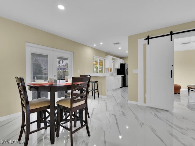 dining room featuring a barn door and french doors