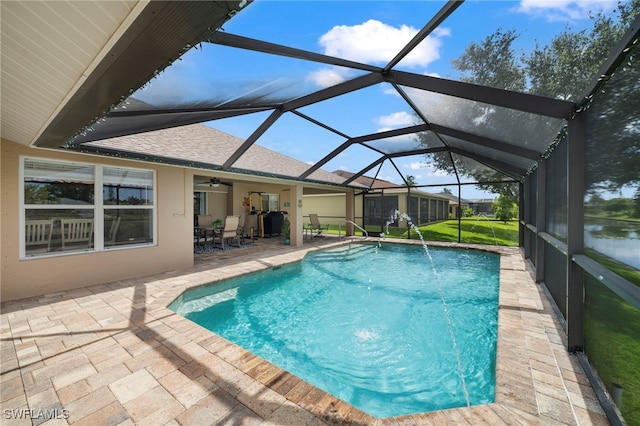 view of pool with a patio, pool water feature, and glass enclosure