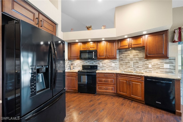 kitchen with decorative backsplash, sink, a high ceiling, and black appliances