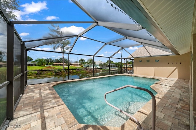 view of swimming pool with a patio area, glass enclosure, and a water view