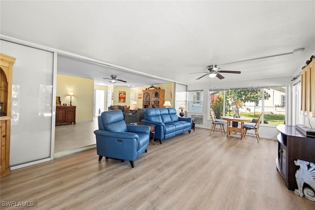 living room with ceiling fan and light wood-type flooring