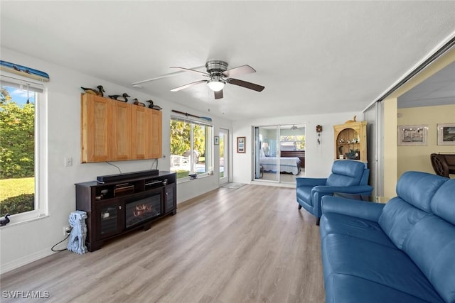 living room with ceiling fan, light wood-type flooring, and a wealth of natural light