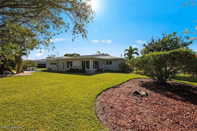 rear view of house featuring a yard