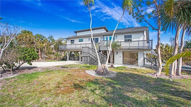 rear view of property with a yard and a deck