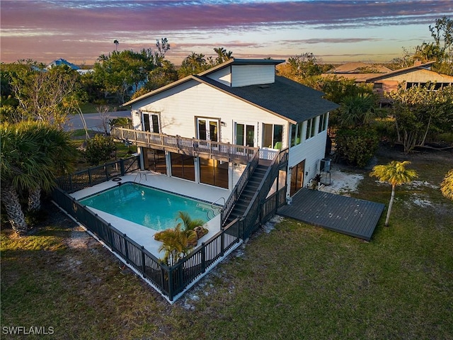 exterior space featuring cooling unit, a wooden deck, and a lawn