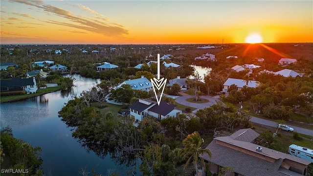 aerial view at dusk featuring a water view