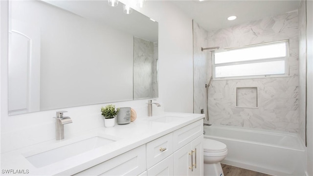 full bathroom featuring hardwood / wood-style flooring, vanity, toilet, and tiled shower / bath combo