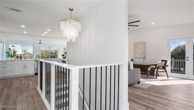 hallway with sink, a chandelier, and light hardwood / wood-style floors