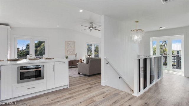 kitchen featuring white cabinetry, a healthy amount of sunlight, oven, and hanging light fixtures