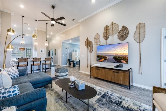 living room with ceiling fan, ornamental molding, and high vaulted ceiling