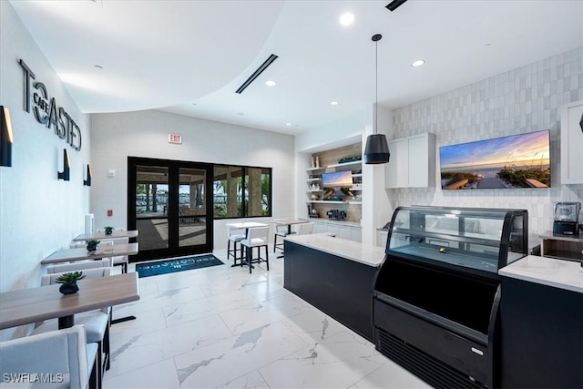 kitchen with white cabinetry, decorative light fixtures, and french doors