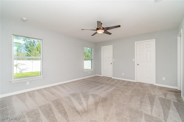 spare room with carpet floors, baseboards, and a ceiling fan