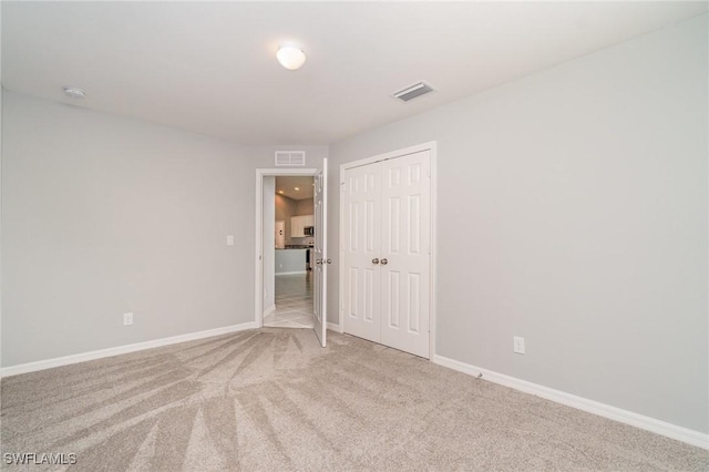 carpeted empty room featuring visible vents and baseboards