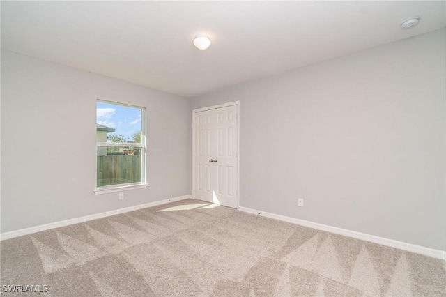 carpeted spare room with baseboards