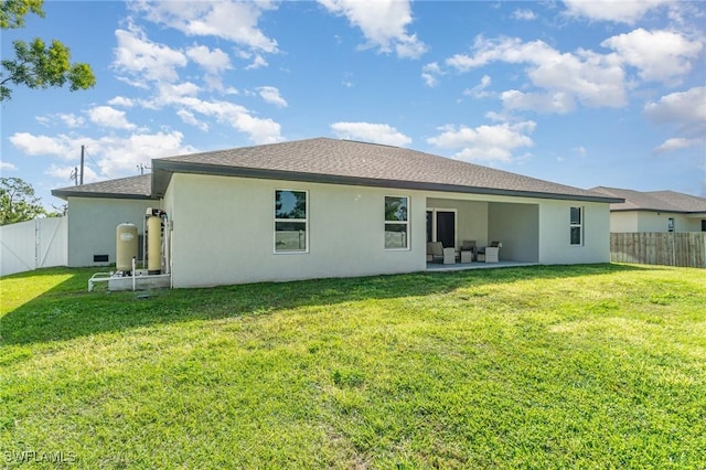 back of house featuring a patio area, a fenced backyard, a lawn, and stucco siding