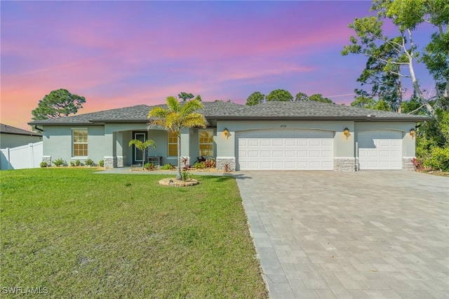 ranch-style house featuring a garage, fence, decorative driveway, and stucco siding