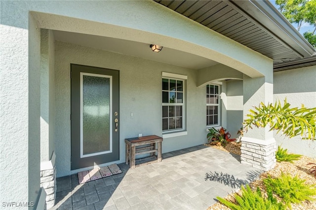 entrance to property featuring stucco siding