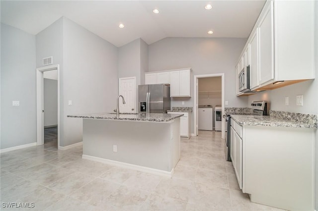 kitchen with a sink, visible vents, white cabinetry, appliances with stainless steel finishes, and independent washer and dryer