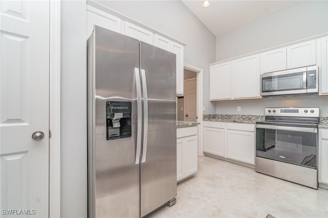 kitchen featuring light stone countertops, white cabinetry, appliances with stainless steel finishes, and light tile patterned flooring