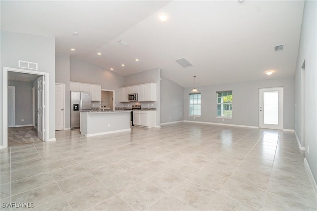 unfurnished living room with high vaulted ceiling, baseboards, light tile patterned floors, and visible vents