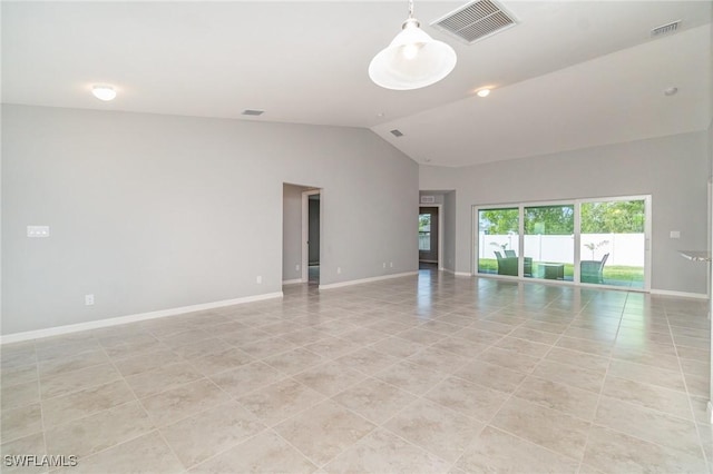 empty room with vaulted ceiling, light tile patterned flooring, visible vents, and baseboards