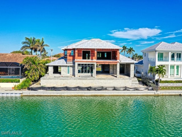 back of property featuring a water view and a patio