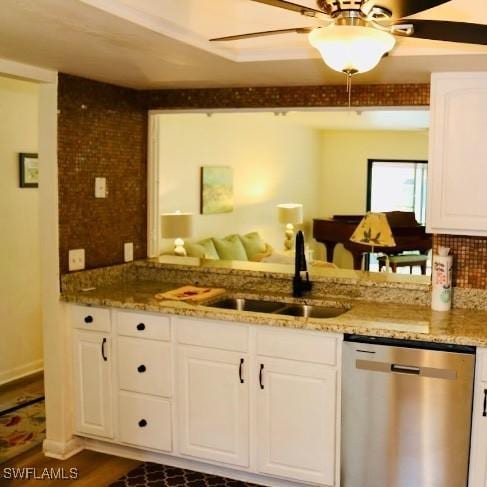 kitchen with stone counters, sink, white cabinets, stainless steel dishwasher, and ceiling fan