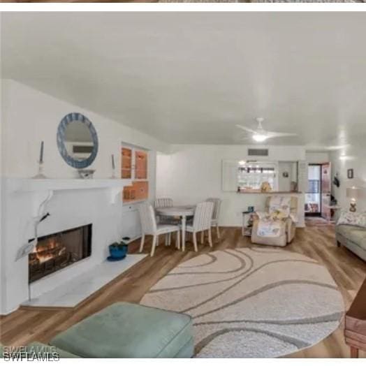 living room featuring ceiling fan and light hardwood / wood-style flooring