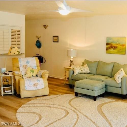 living room featuring wood-type flooring and ceiling fan