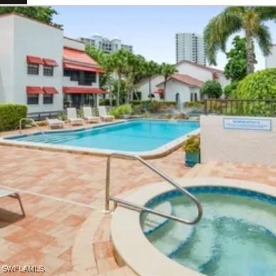 view of swimming pool with a community hot tub and a patio