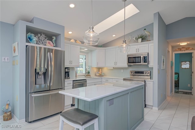 kitchen featuring a kitchen bar, appliances with stainless steel finishes, a kitchen island, pendant lighting, and white cabinets