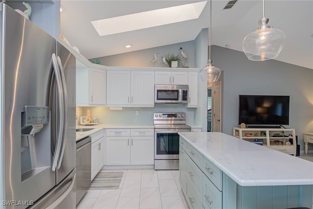 kitchen featuring white cabinetry, appliances with stainless steel finishes, pendant lighting, and vaulted ceiling with skylight