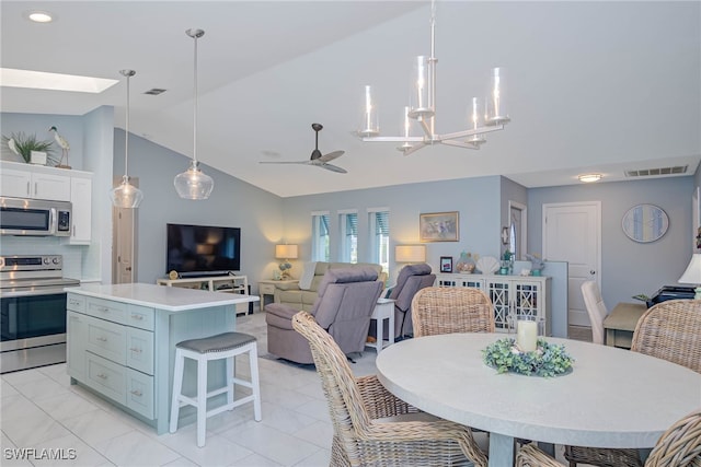 dining space with ceiling fan with notable chandelier and high vaulted ceiling