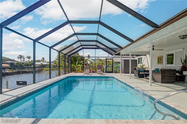 view of pool featuring a lanai, ceiling fan, outdoor lounge area, a water view, and a patio area