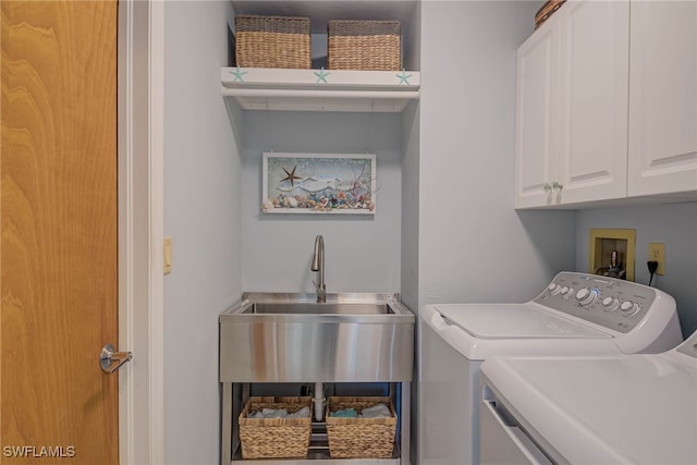 laundry room featuring independent washer and dryer, cabinets, and sink