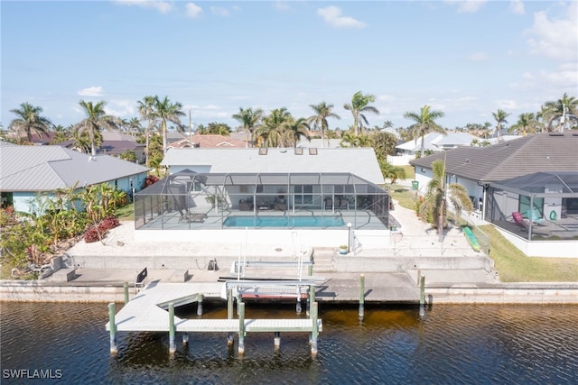 rear view of house featuring a water view and glass enclosure