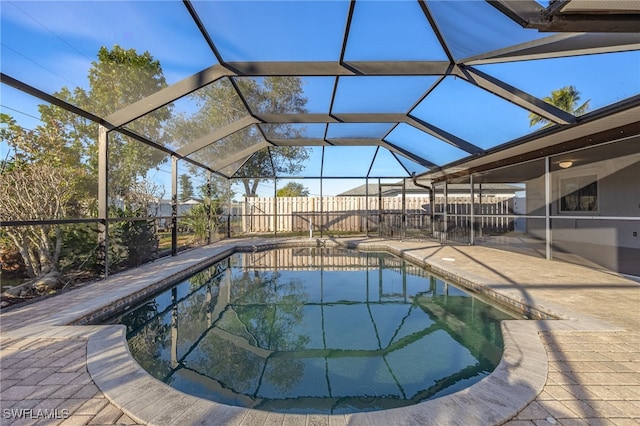 view of swimming pool featuring a patio area and glass enclosure