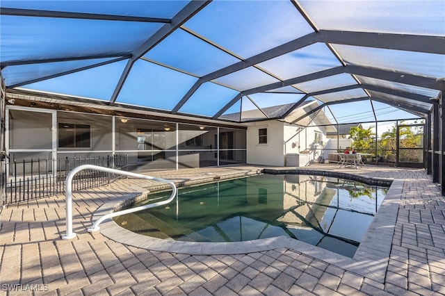 view of swimming pool featuring a patio and glass enclosure