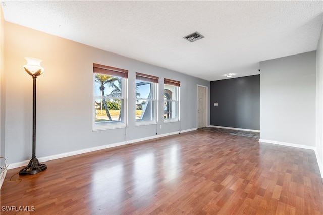 empty room featuring hardwood / wood-style flooring and a textured ceiling