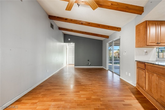 interior space with lofted ceiling with beams, ceiling fan, and light hardwood / wood-style floors