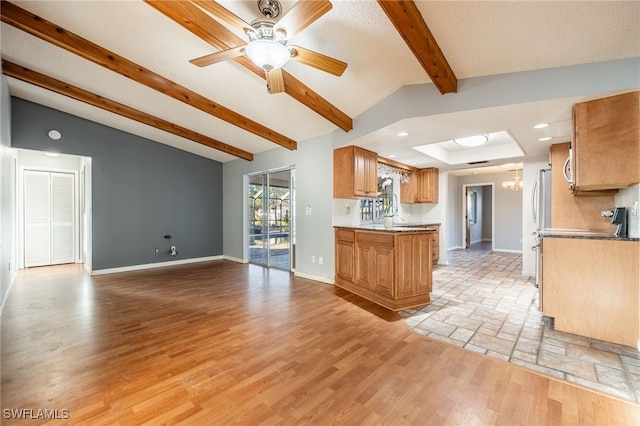 kitchen with vaulted ceiling with beams, ceiling fan with notable chandelier, a textured ceiling, and light wood-type flooring