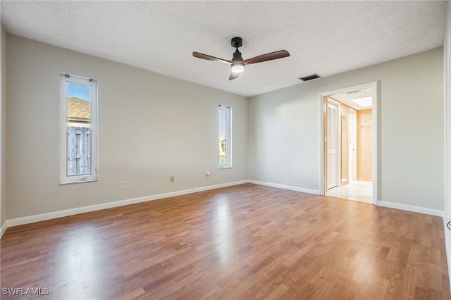 unfurnished room with ceiling fan, a textured ceiling, and light hardwood / wood-style floors