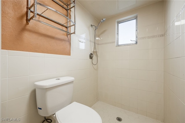 bathroom featuring tile walls, toilet, and tiled shower