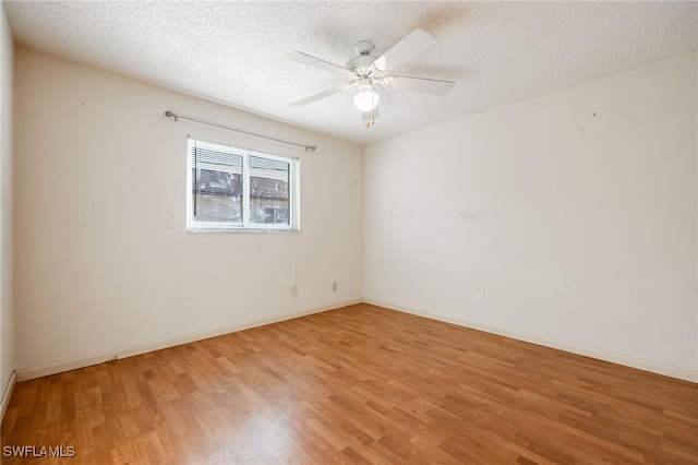 empty room with ceiling fan, hardwood / wood-style floors, and a textured ceiling