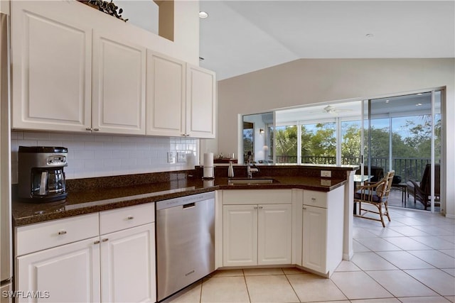 kitchen featuring light tile patterned floors, stainless steel dishwasher, white cabinetry, vaulted ceiling, and a sink