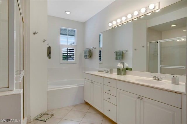 full bath featuring double vanity, a stall shower, a garden tub, tile patterned flooring, and a sink