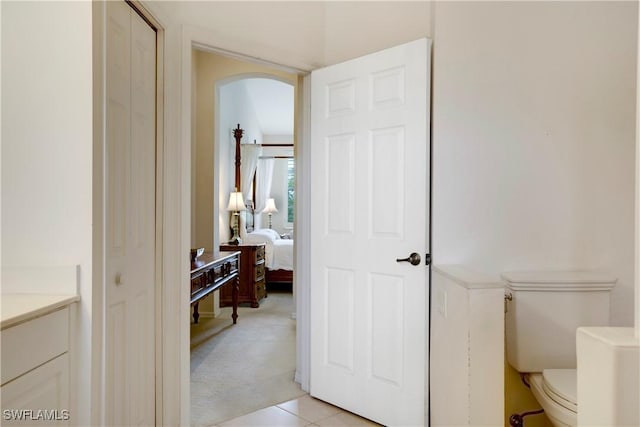 ensuite bathroom with connected bathroom, vanity, and toilet