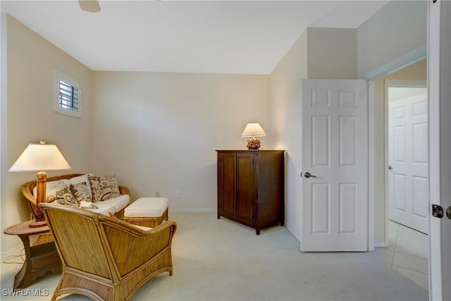 living area featuring baseboards and light colored carpet