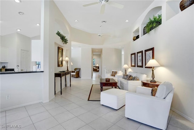 living room with ceiling fan, light tile patterned flooring, a towering ceiling, and recessed lighting